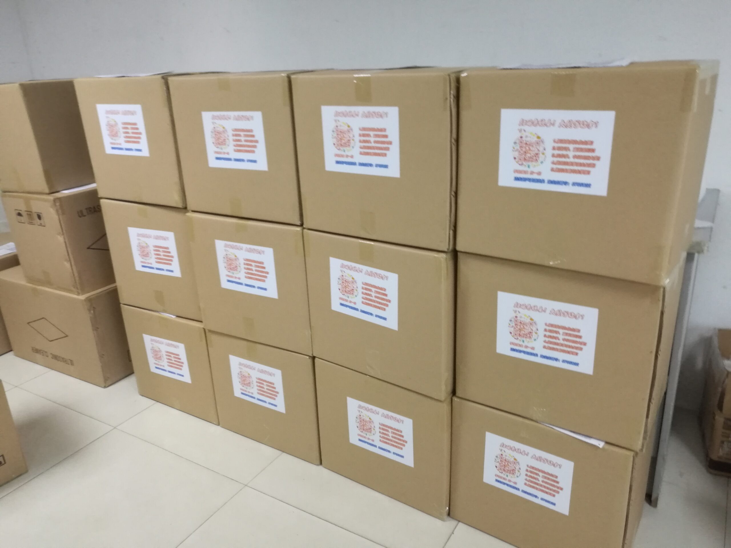 The Image Shows Several Stacked Cardboard Boxes With Labels, Likely Containing Ultrasonic Cleaners Or Related Equipment Ready For Shipment.
